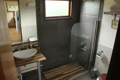 a bathroom with a sink and a glass shower at cabañas Tierra Kamiare 1 in Amboy