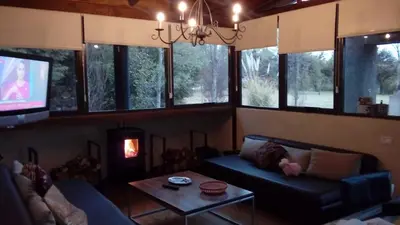 a living room with a couch and a tv at cabañas Tierra Kamiare 1 in Amboy