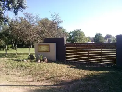 a fence with a sign on it next to a field at cabañas Tierra Kamiare 1 in Amboy