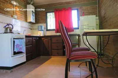 a kitchen with a table and two chairs in it at Cabañas A la Maison in Mina Clavero