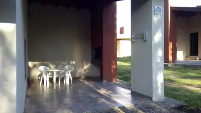 a table and two white chairs on a patio at Aldea del Río in Santa Rosa de Calamuchita