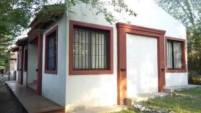 a house with two doors and a porch at Aldea del Río in Santa Rosa de Calamuchita