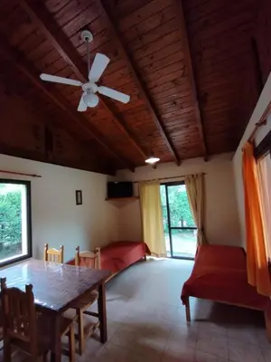a dining room with a table and a ceiling fan at Aldea del Río in Santa Rosa de Calamuchita