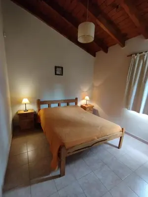 a bedroom with a bed and two lamps on two tables at Aldea del Río in Santa Rosa de Calamuchita