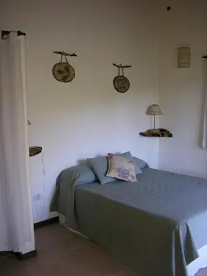 a bedroom with a bed with a blue comforter and twowheels on at Fincas del Huacle in Nono