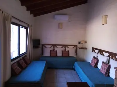 a room with two blue beds and a window at Fincas del Huacle in Nono