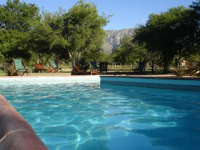 a swimming pool with chairs and mountains in the background at Fincas del Huacle in Nono