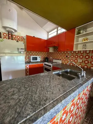 a kitchen with red cabinets and a granite counter top at Mi Sueño in San Antonio de Arredondo