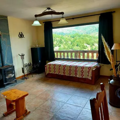 a bedroom with a bed and a large window at La Ponderosa Cumbrecita in La Cumbrecita