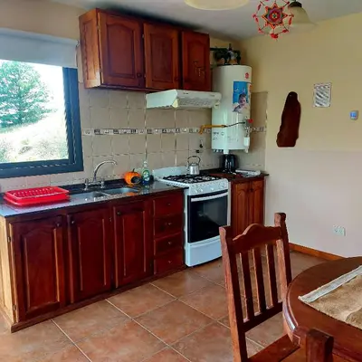 a kitchen with a sink and a stove top oven at La Ponderosa Cumbrecita in La Cumbrecita
