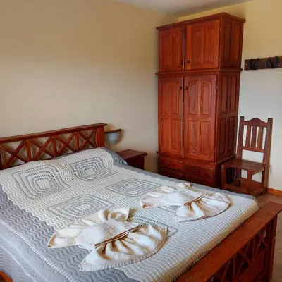 a bedroom with a bed with a wooden dresser at La Ponderosa Cumbrecita in La Cumbrecita