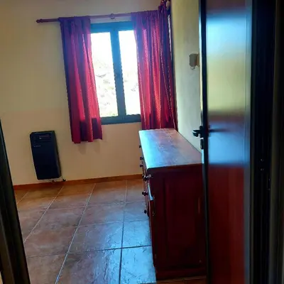 a kitchen with red curtains and a window at La Ponderosa Cumbrecita in La Cumbrecita