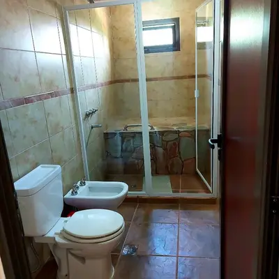 a bathroom with a toilet and a shower and a sink at La Ponderosa Cumbrecita in La Cumbrecita