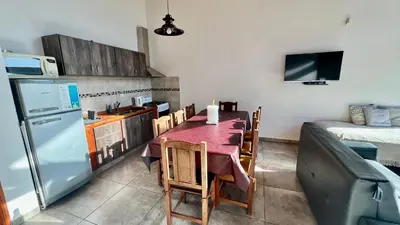 a small kitchen with a table and a refrigerator at Fincas del Faldeo in Villa General Belgrano