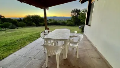 a white table and chairs on a patio with a view at Fincas del Faldeo in Villa General Belgrano