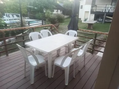 a white table and chairs on a deck at Cabañas Noscohue in Villa General Belgrano