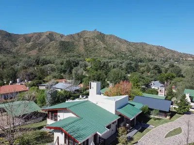 an aerial view of a house with a mountain in the background at Cabañas Noscohue in Villa General Belgrano