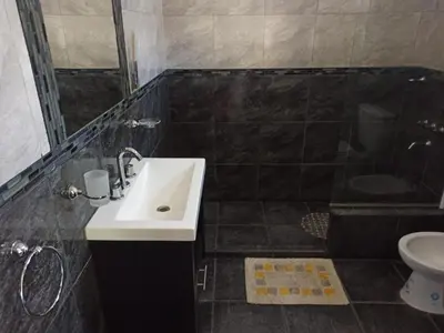 a bathroom with a sink and a shower and a toilet at Cabañas Noscohue in Villa General Belgrano