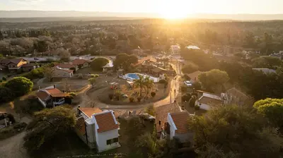 an aerial view of a residential suburb with the sun setting at Cabañas Loma Azul in Villa General Belgrano