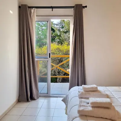 a bedroom with a bed and a large window at Cabañas Loma Azul in Villa General Belgrano