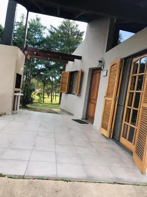 a house with wooden doors and a patio at Cabañas Loma Azul in Villa General Belgrano