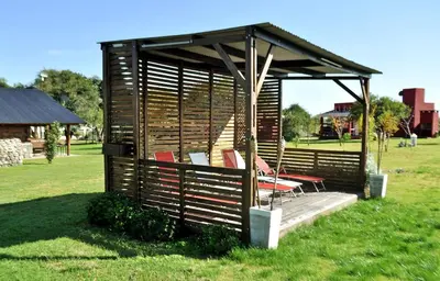 a gazebo with chairs and tables in a field at Cabañas Las Troncas in Merlo