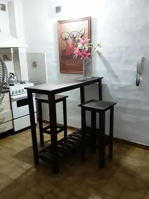 a table with two stools and a vase with flowers at TEMPORARIO CORDOBA in Cordoba