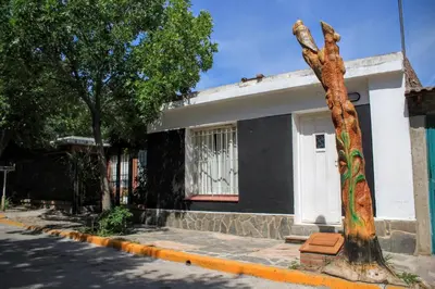 a tree in front of a house with a building at flia Fortuna in Mina Clavero