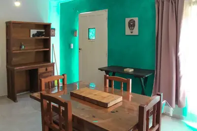 a dining room with a table and a green wall at flia Fortuna in Mina Clavero
