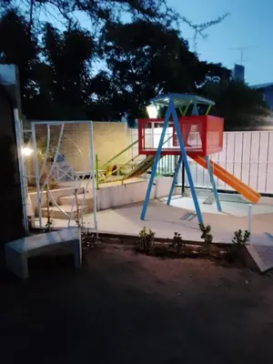 a playground with a slide in front of a fence at Complejo Quiya - Casa El Algarrobo in Alta Gracia