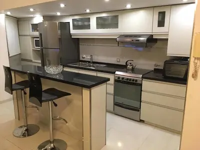 a kitchen with stainless steel appliances and black counter tops at Fabuloso Carlos Paz in Villa Carlos Paz
