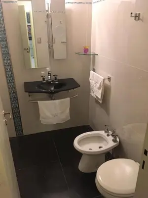 a bathroom with a white toilet and a sink at Fabuloso Carlos Paz in Villa Carlos Paz