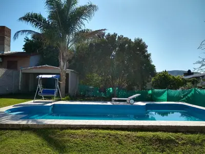 a small swimming pool in a yard with a palm tree at Casa Grande in Villa Carlos Paz