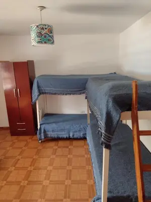 a room with a bunk bed with a blue blanket at Casa Grande in Villa Carlos Paz
