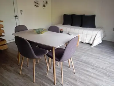 a dining room table with chairs and a couch at Cabañas Piedras del Xanaes, colindantes al río in Villa Los Aromos