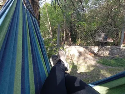 a person is laying in a hammock at Cabañas Piedras del Xanaes, colindantes al río in Villa Los Aromos