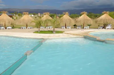a pool with chairs and umbrellas in a resort at Arenas Blancas Cabañas & Suites in Nono