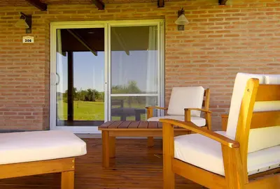 a porch with two chairs and a bench and a window at Arenas Blancas Cabañas & Suites in Nono