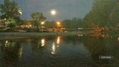 a moon over a body of water at night at departamentos sosa in Mina Clavero