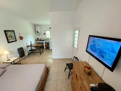 a bedroom with a bed and a large screen television at Rumihuasi Apartamento in Los Reartes