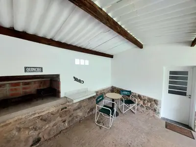 a room with a table and chairs and a fireplace at Rumihuasi Apartamento in Los Reartes