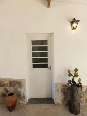 a white door with a window and a potted plant at Rumihuasi Apartamento in Los Reartes