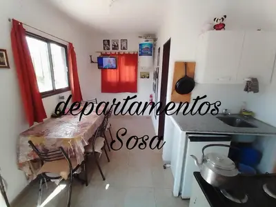 a kitchen with a table and a refrigerator at DEPARTAMENTOS SOSA in Mina Clavero