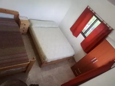 a small bedroom with a bed and a window at DEPARTAMENTOS SOSA in Mina Clavero