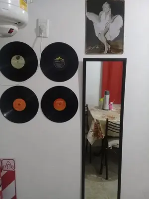 a wall with records hanging on a wall with a mirror at DEPARTAMENTOS SOSA in Mina Clavero