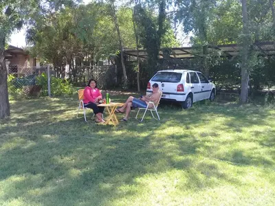 two people sitting at a table in a yard at DEPARTAMENTOS SOSA in Mina Clavero