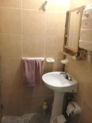 a small bathroom with a sink and a mirror at DEPARTAMENTOS SOSA in Mina Clavero