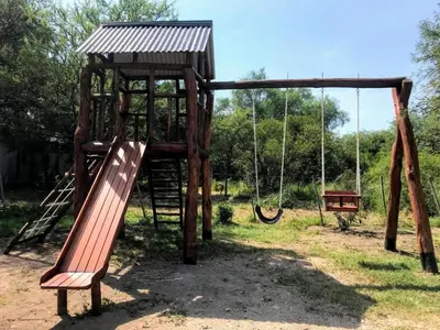 a playground with a slide and a swing at Mirador del Valle in Mina Clavero