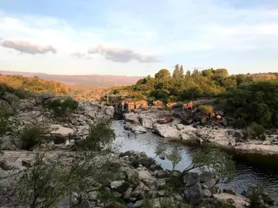 a river in the middle of a rocky terrain at Mirador del Valle in Mina Clavero