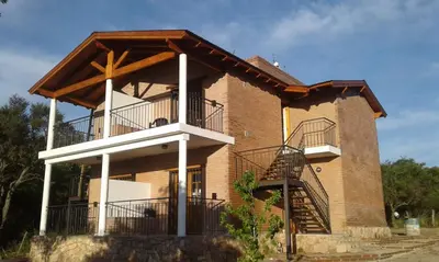 a large brick building with a balcony and stairs at Mirador del Valle in Mina Clavero
